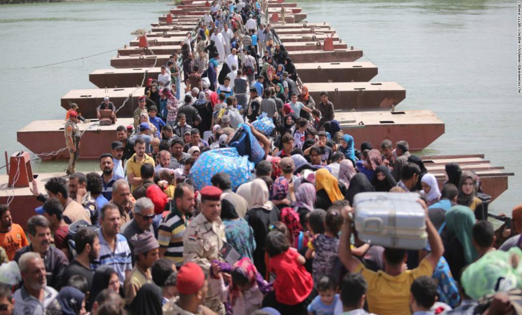 Thousands of Iraqis cross a bridge over the Euphrates River to  Baghdad, as they flee Ramadi, Iraq, on Friday, April 17. The city of Ramadi has been embroiled in clashes with ISIS militants. 