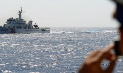 Một nhân viên bảo vệ bờ biển Việt Nam chụp ảnh một con tàu của Lực lượng bảo vệ bờ biển Trung Quốc trên Biển Đông vào ngày 14/5/2014, ngoài khơi bờ biển miền Trung Việt Nam. Chính quyền Trung Quốc hiện đang bảo vệ không phận trên khu vực này. (Ảnh: Hoàng Đình Nam/AFP/Getty Images)