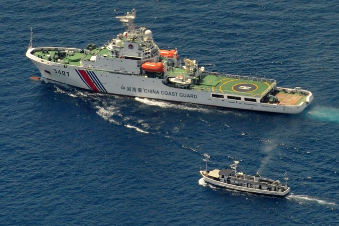 Một chiếc chiến thuyền Bảo vệ Bờ biển của Trung Quốc (phía trên) và một chiếc thuyền cung ứng của Philippines rơi vào tình trạng giằng co vì tàu Philippines muốn tiến đến Bãi Cỏ Mây (Second Thomas Shoal), một rạn san hô xa xôi ở Biển Đông được cả hai nước tuyên bố chủ quyền, ngày 29 tháng 3 năm 2014 ( Jay Directo/AFP/Getty Images)