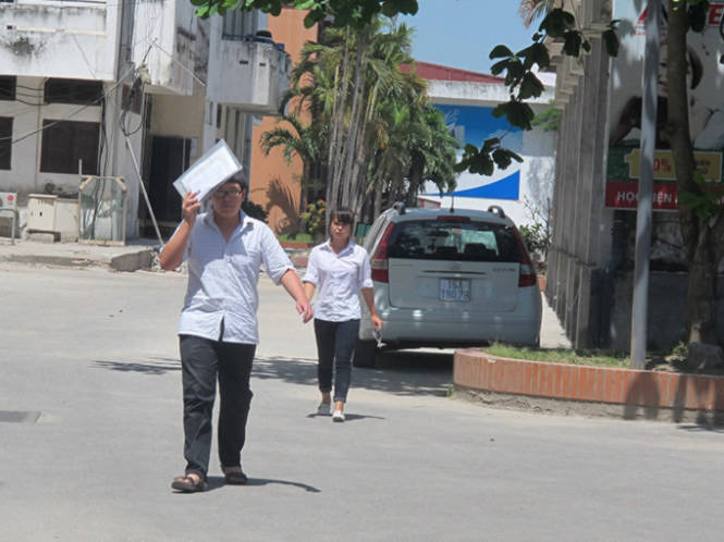 Những thí sinh làm bài xong và ra ngoài sớm vì thời tiết nắng nóng tại điểm thi A trường đại học Hàng Hải Việt Nam - Ảnh: Thân Hoàng