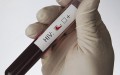 gloved hand holding test tube with blood sample  and label indicating HIV negative test result