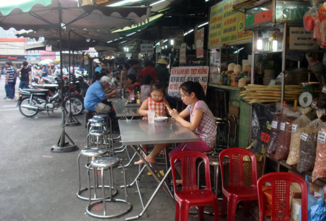 Bạn Nguyễn Trọng Minh: "Ở miền Bắc vào, tôi thú vị nhất là các quán ăn vỉa hè khu trung tâm TP.HCM rất sạch sẽ, gọn ghẽ và giá cả không hề phân biệt người ở đâu, trong hay ngoài nước đều giá như nhau" - Trong ảnh dãy quán vỉa hè bên hông chợ Tân Định, một chợ Sài Gòn xưa trưa 12-12 - Ảnh: M.C