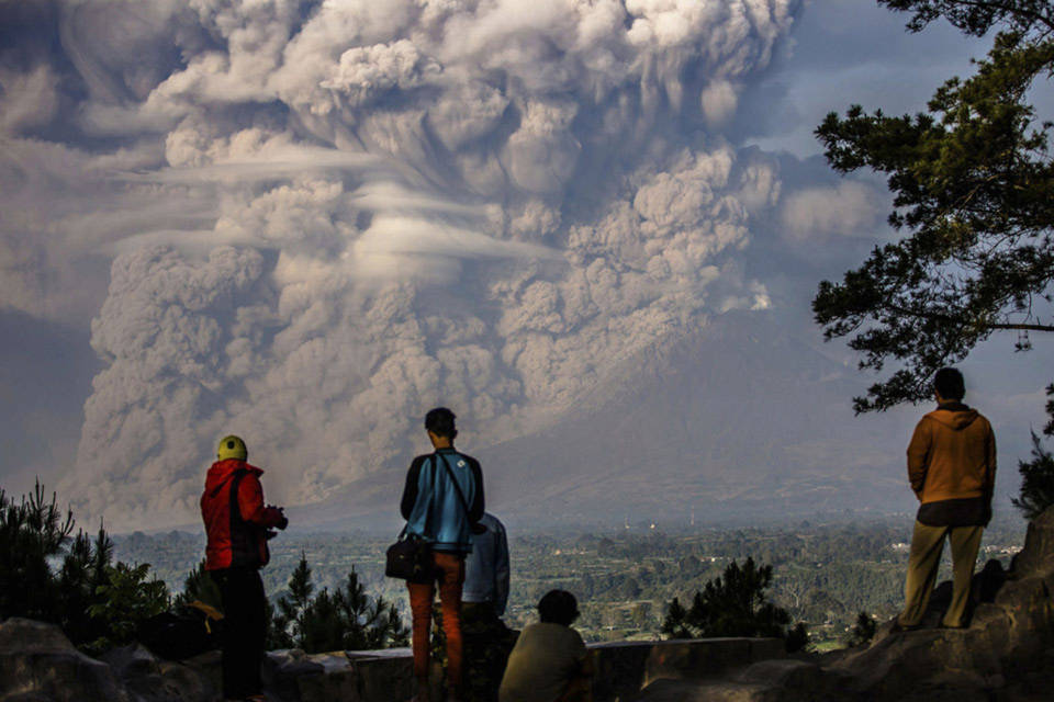 Người dân xung quanh đứng xem núi Sinabung phun tro vào không khí trong một vụ phun trào tại Karo Regency, Indonesia, vào ngày 09 tháng 02 năm 2015.