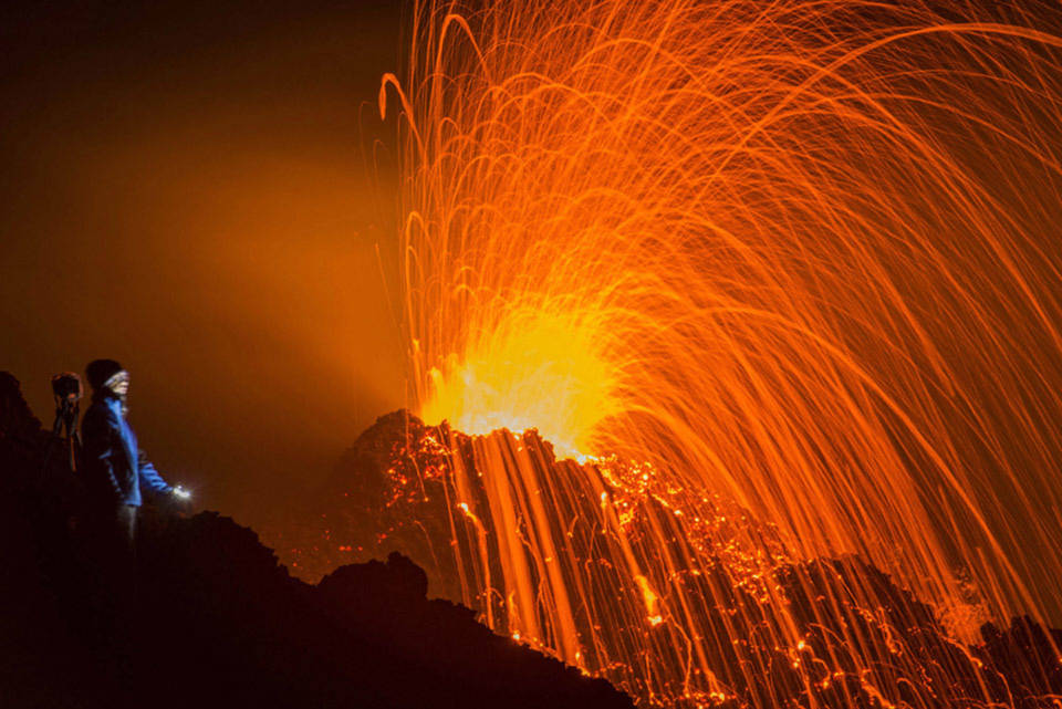 Một người đứng nhìn ngọn núi lửa Piton de la Fournaise trong vụ phun trào vào ngày 05 tháng 02 năm 2015, tại đảo French Indian Ocean thuộc Réunion Island.