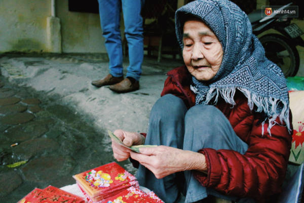 Hình ảnh cụ bà ngồi vỉa hè Hà Nội bán bao lì xì giữa trời giá rét khiến nhiều người cảm động - Ảnh 2. Hình ảnh cụ bà ngồi vỉa hè Hà Nội bán bao lì xì giữa trời giá rét khiến nhiều người cảm động - Ảnh 2.