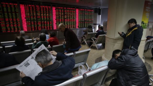Các nhà đầu tư theo dõi giá cổ phiếu tại một trung tâm môi giới chứng khoán ở Bắc Kinh, ngày 5/1/2016.