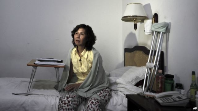 Bà Nghê Ngọc Lan ngồi trên giường trong một khách sạn ở Bắc Kinh.