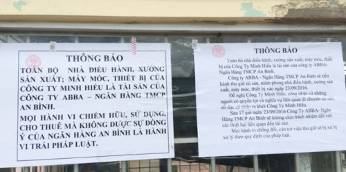 Nhóm người mặc trang phục vệ sĩ đến dán thông báo có đóng dấu của ngân hàng TMCP An Bình và cấm xe ra vào công ty Minh Hiếu. Ảnh: Phúc Hưng