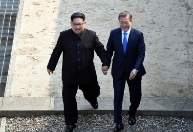 Ông Kim Jong Un và Moon Jae In nắm tay nhau bước qua dải phân cách biên giới Nam-Bắc Triều Tiên ngày 27/4/2018 (Ảnh: Press Pool)