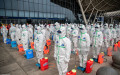 TOPSHOT - Staff members line up at attention as they prepare to spray disinfectant at Wuhan Railway Station in Wuhan in China's central Hubei province on March 24, 2020. - China announced on March 24 that a lockdown would be lifted on more than 50 million people in central Hubei province where the COVID-19 coronavirus first emerged late last year. (Photo by STR / AFP) / China OUT (Photo by STR/AFP via Getty Images)